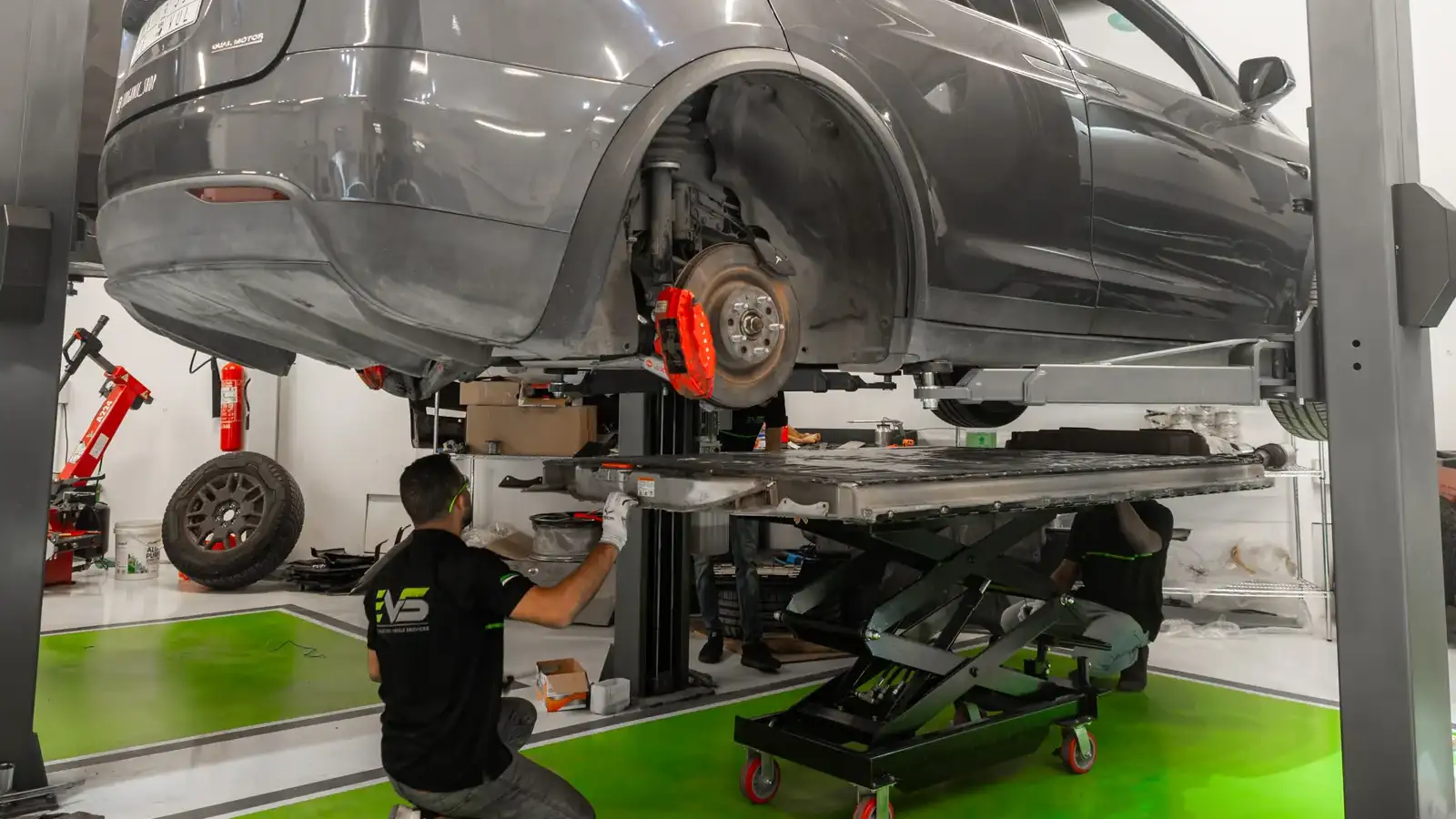 سيارة تسلا على رافعة في ورشة EVS بالرياض أثناء صيانة البطارية